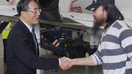 Chinese ambassador Wang Xiao shakes hands with one of four freed workers at the airport in Bogota, on November 22