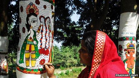Madhubani art being painted on a tree