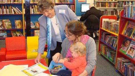 Volunteer Vera Wall with library user Sabrina Atkins and her daughter