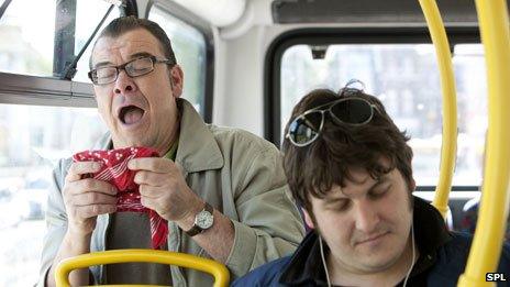 Man sneezing on a bus