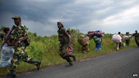 M23 rebels run towards the town of Sake, 26km west of Goma, as thousands of residents flee fresh fighting in the eastern Democratic Republic of the Congo town on November 22, 2012
