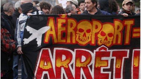 Demonstrators hold a banner saying "Airport, Stop" at a demonstration on Saturday