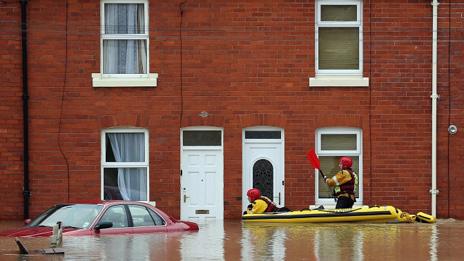An RNLI life boat crew work in the flooded streets of St Asaph on Tuesday