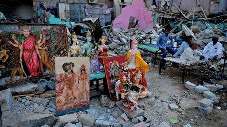 Pakistani Hindus sit next to a demolished Hindu temple in Karachi on December 2, 2012