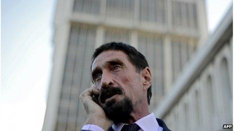 John McAfee speaks on his mobile phone in front of the Supreme Court in Guatemala City on December 04