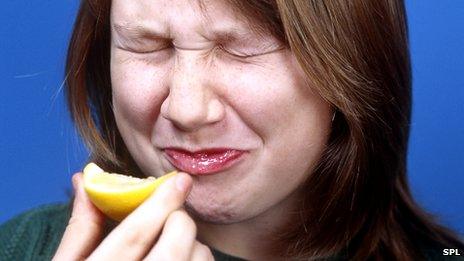 Woman biting into a lemon