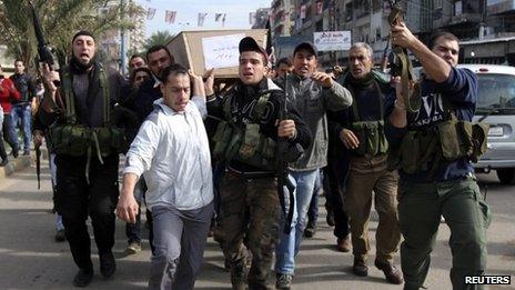Lebanese Islamist gunmen carry the coffin of a man recently killed in Syria through the city of Tripoli (10 December 2012)