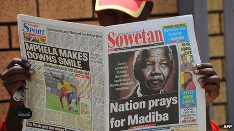 A man reads a newspaper with news about Nelson Mandela's health in Johannesburg (10 December 2012)