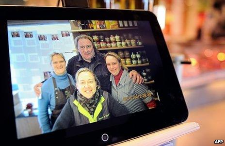 A photo taken on 12 December in the Belgian village of Estaimpuis shows a photo on a tablet featuring French actor Gerard Depardieu posing on 7 December with the local butcher and her employees