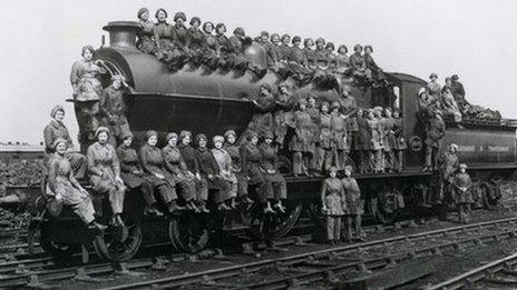 Women locomotive cleaners sitting on an engine, Bradford, West Yorkshire, 23 March 1917