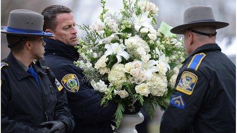 Police officers help with flowers at the funeral of Noah Pozner, aged six, in Fairfield, Connecticut, 17 December 2012