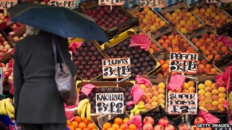 Woman surveys fruit for sale at a market