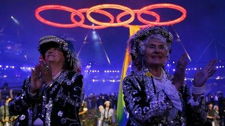 Performers clap as the Olympic rings are seen above, during the opening ceremony of the London 2012 Olympic Games