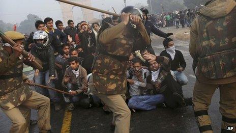Protesters shield themselves as Indian police prepare to beat them with sticks during a violent demonstration near the India Gate against a gang rape and brutal beating of a 23-year-old student on a bus last week, in New Delhi, India, Sunday, Dec. 23, 2012.