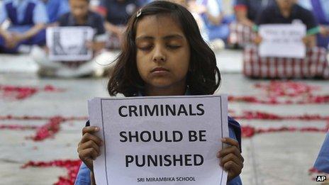 An Indian schoolgirl holds a placard during a prayer ceremony to mourn the death of a 23-year-old gang rape victim, at a school in Ahmadabad, India, Saturday, Dec. 29, 2012.