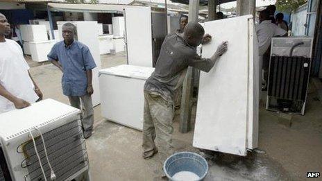 Man cleaning a fridge in Ivory Coast (file photo)