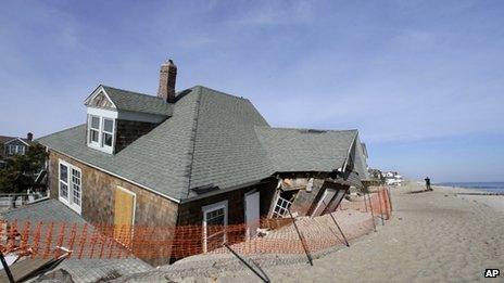A man photographs a severely damaged beach front home in Bay Head, New Jersey, 3 January 2013