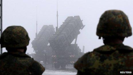 German soldiers look at Patriot missile batteries in Warbelow, northern Germany, on 18/12/12