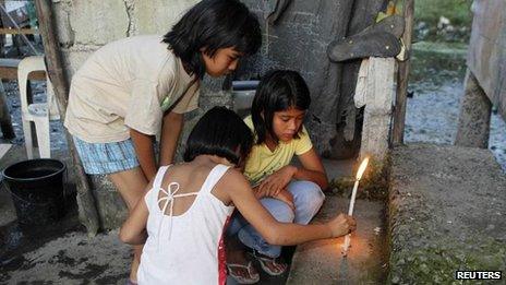 Relatives of shooting victim Micaella Andrea Caimol light candles at the steps of her house in the Cavite province, 4 January