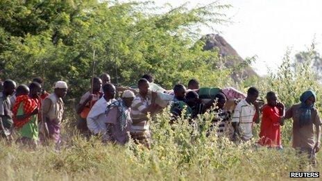 Residents carry the body of a man killed when their village was attacked in Kenya's Tana Delta region, 9 January 2013