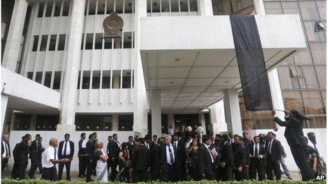 Sri Lankan lawyers hang a black flag as a sign of protest against the government's impeachment bid outside the Colombo court complex