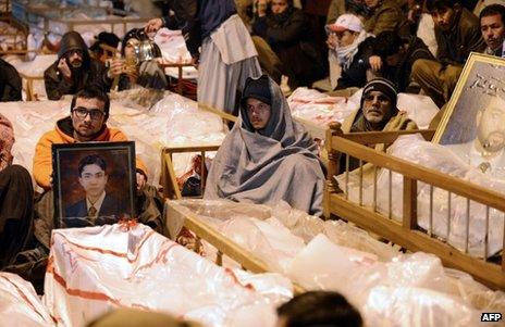 Protesting mourners sit by the shrouded bodies of their dead in Quetta, Pakistan, 12 January