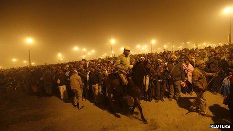 A policeman mounted on his horse maintains order during the first "Shahi Snan" (grand bath) at the ongoing "Kumbh Mela