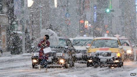 Woman walks through the snow in Ginza shopping district of Tokyo, Japan (14 Jan 2013)