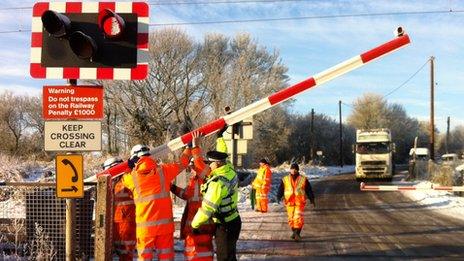 Workers fixing level crossing barrier