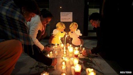 Women place candles outside the Public Ministry building to demand justice for the murdered girls