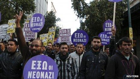 Immigrants hold banners reading "Neonazis Out" during an anti-racism rally in Athens, 19 January 2013