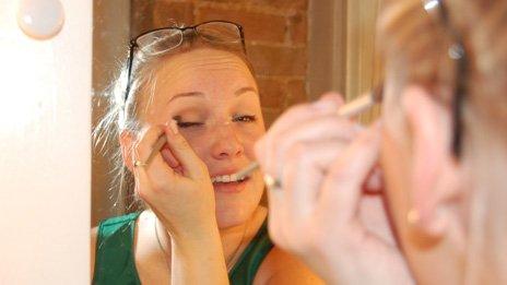 Jillian Rae Greenwood applying make up in the mirror