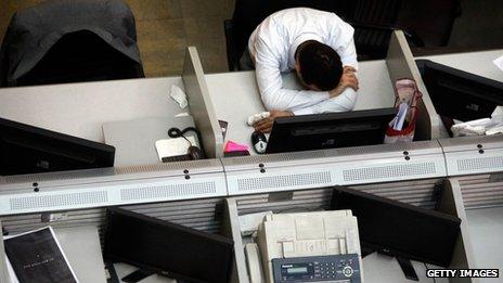 A man slumps at his desk