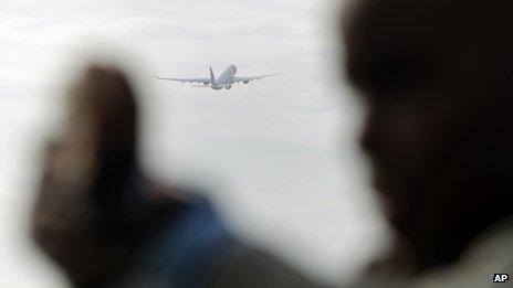 A boy takes a photograph as a Portuguese national airline TAP airplane takes off from Lisbon's Portela international airport, file pic from 20 December 2012
