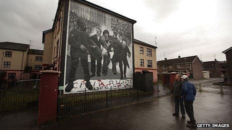 Two men looking at mural depicting the events of Bloody Sunday in Londonderry, 1972