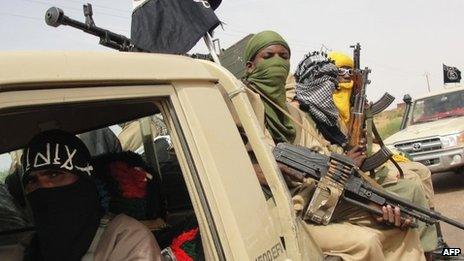 A picture taken on 7 August 2012 shows fighters of the Ansar Dine Islamist group standing guard at Kidal airport, northern Mali