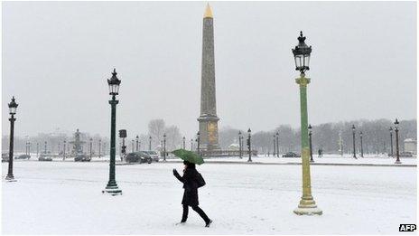 A woman walks on the snow covered Place de la Concorde, Paris