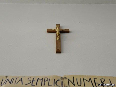 Latin banner reading "units, simple, numbers" under a crucifix in an Italian classroom