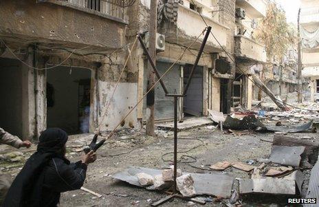 An opposition fighter uses a catapult to launch a handmade grenade in Aleppo, Syria, 12 February