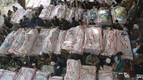 Pakistani Shiite Muslims gather around the coffins of bomb attack victims as they demonstrate in Quetta on February 18