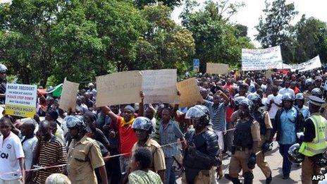 Escorted by heavily armed riot police, people march on the streets of Blantyre on 17 January 2013 to protest against government's IMF backed tough reforms designed to right the economy and win back investors