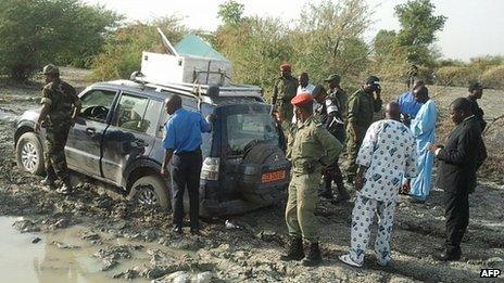 Cameroonian soldiers and officials surround the car from which a French family of seven were kidnapped