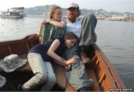 Andrew Turner takes a ride in his boat, Karuna, on the Yamuna with his daughters Gemma and Elle