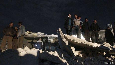 People gather at the site of what activists say was a Scud missile attack on Aleppo on 22 February 2013