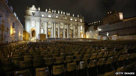 Chairs are laid out in front of the illuminated Basilica in Saint Peter's Square, Rome