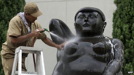 A city worker cleans a statue by Colombian artist Fernando Botero in Medellin