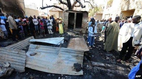 People look at the scene of the fire at a Koranic school in Dakar, Senegal (4 March 2013)