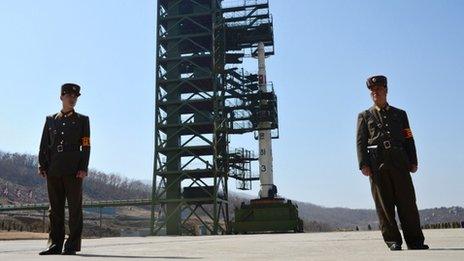 This file photo taken on April 8, 2012 shows two North Korean soldiers standing guard in front of the Unha-3 rocket at Tangachai -ri space center