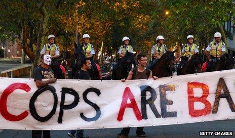 Protestors holding banner while police look on