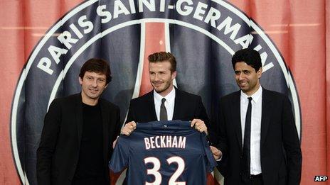 David Beckham flanked by PSG sports director Leonardo (L) and PSG Qatari president Nasser Al-Khelaifi